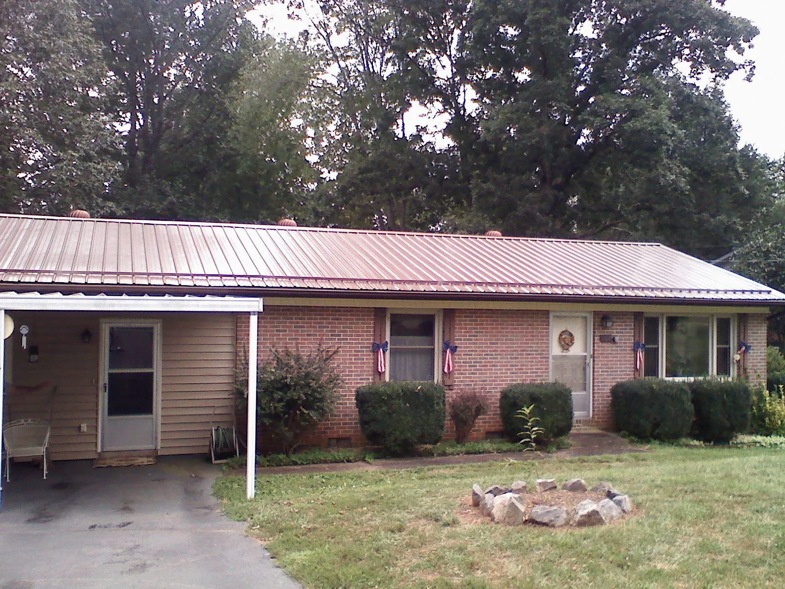 Bronze metal roof and carport on a brick ranch home — Roof Repair work by our crew in Mc Kinney