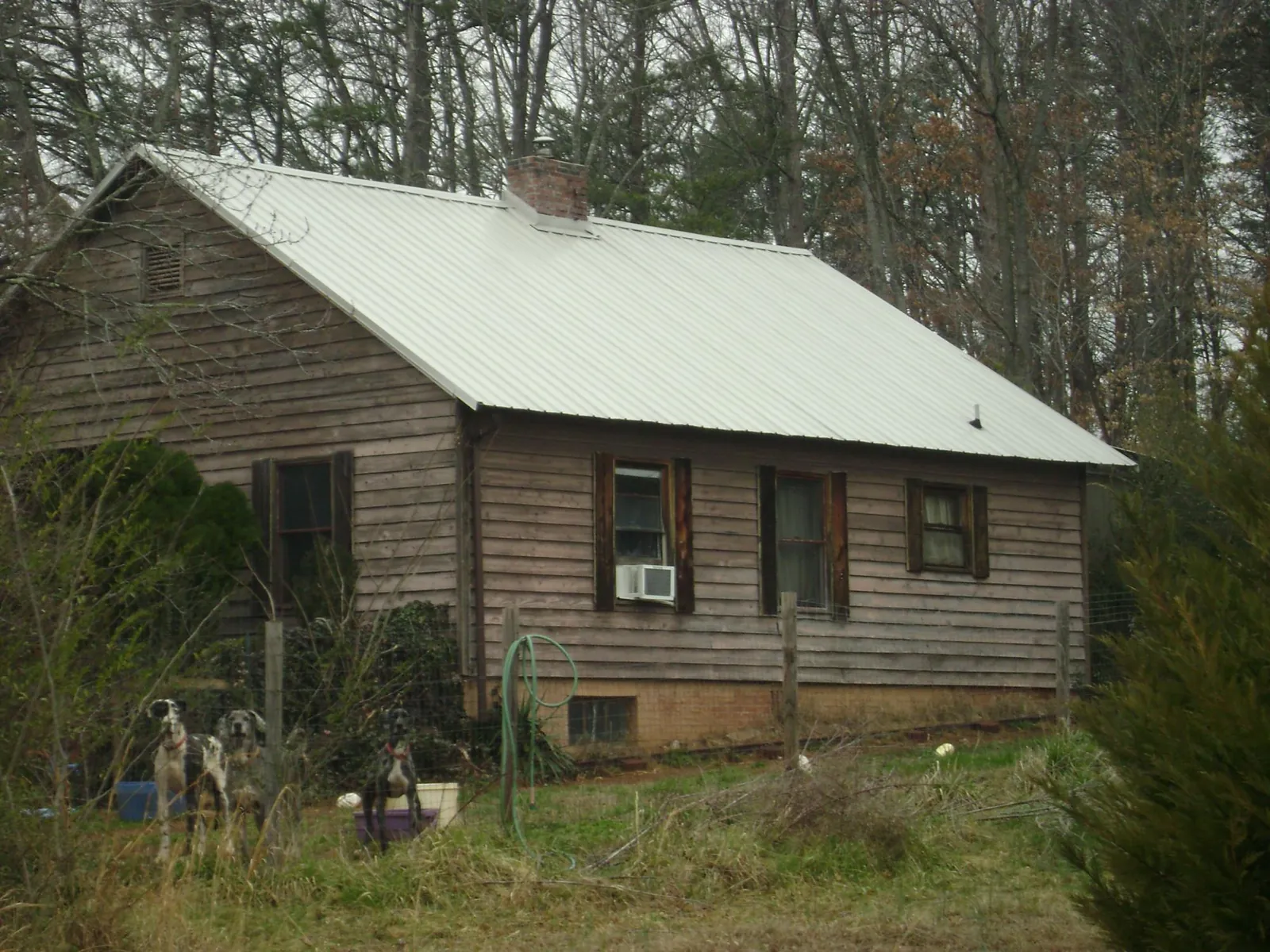 White metal roof on an old wood sided farmhouse, from a Metal Roof Installation job in Mc Kinney